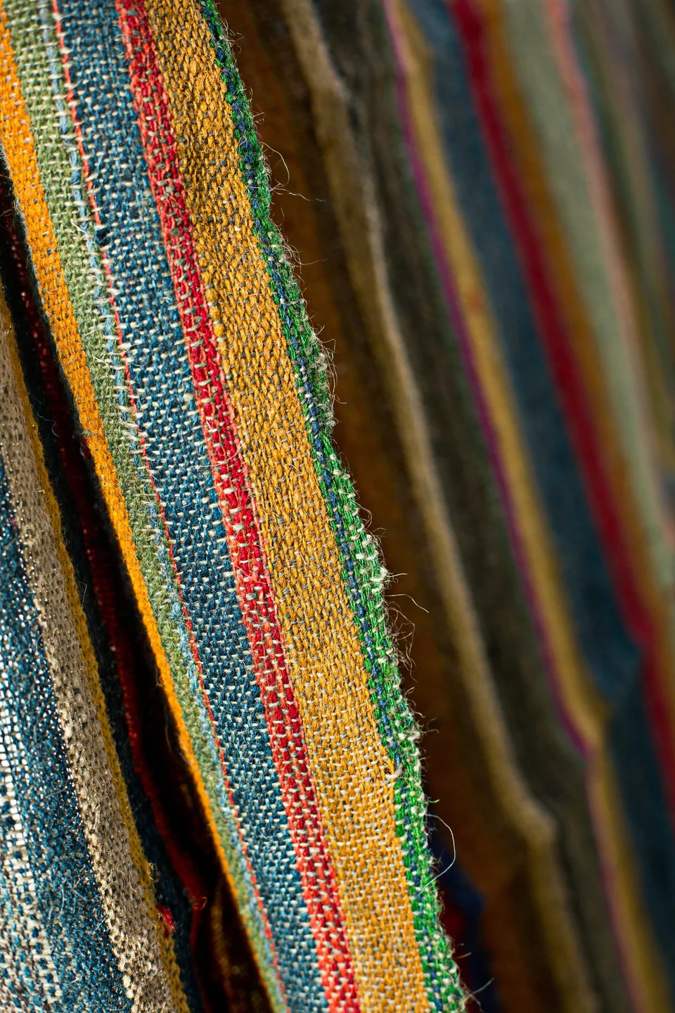 Handwoven Bhujodi wool stacked so the striped edges show