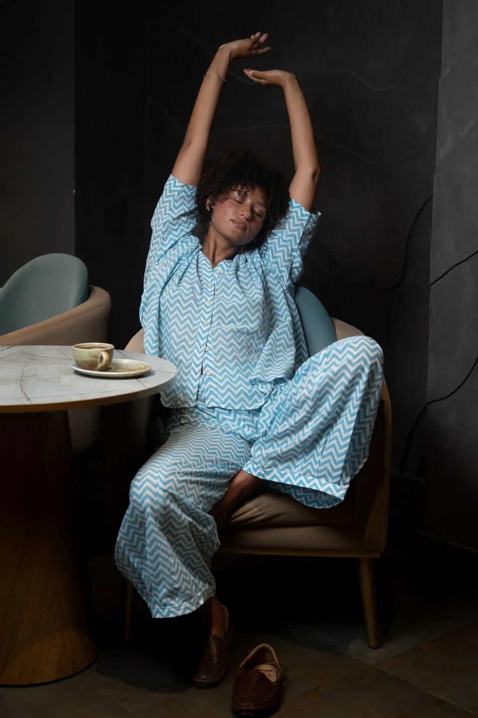 Block-printed blue shirt and trousers, arms stretched overhead