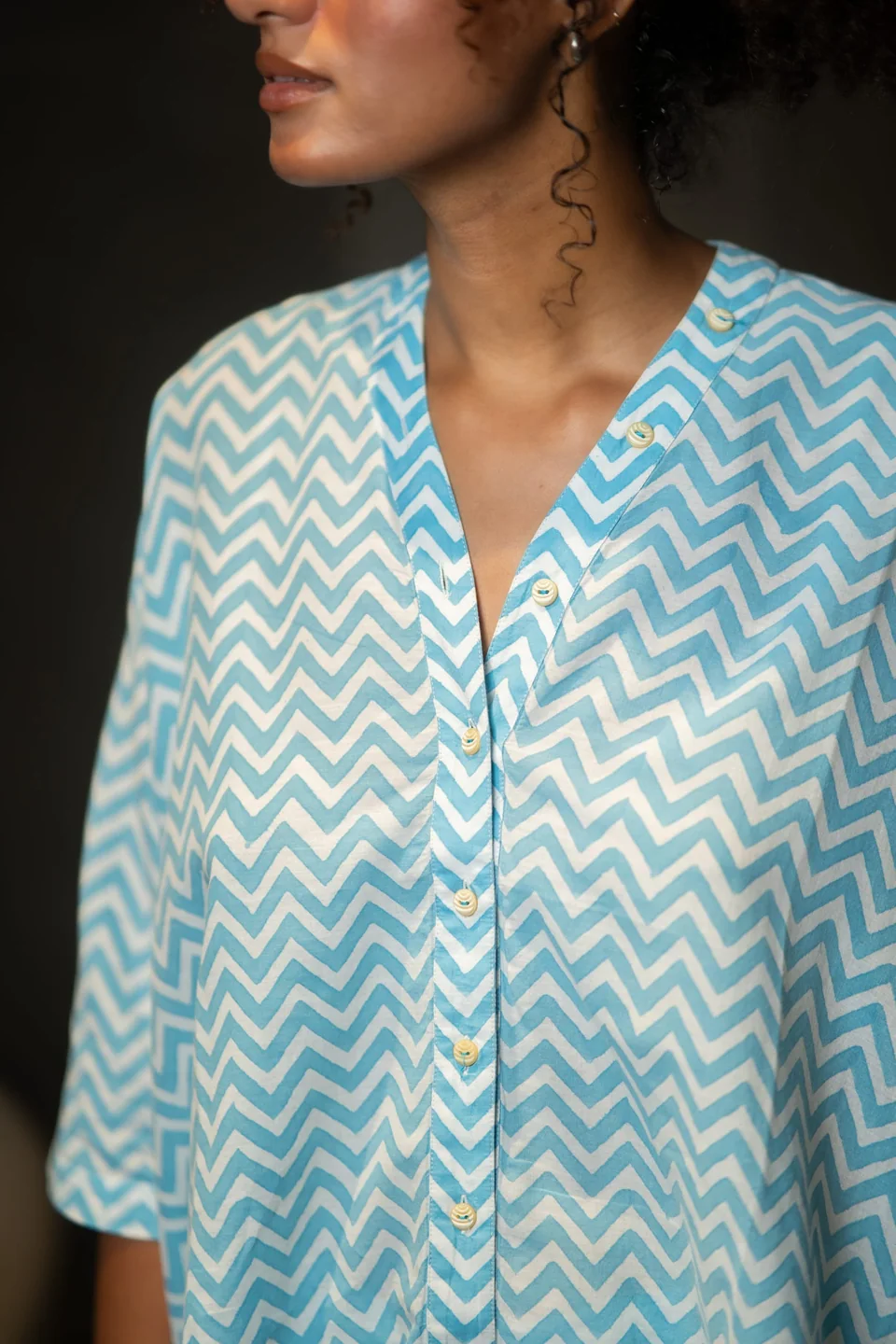Close view of the blue chevron top's V neckline and small buttons