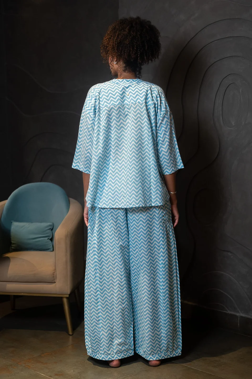 Back view of the blue chevron trousers and top, wide legs falling straight