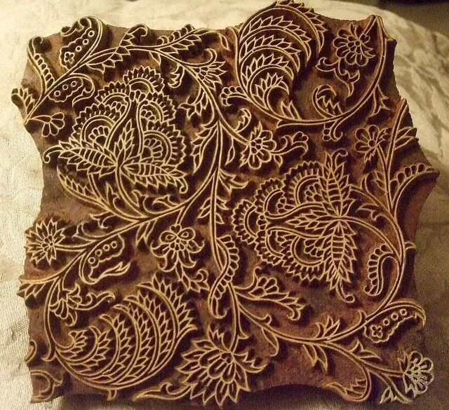 A hand-carved teak printing block, paisley and vine cut into the wood