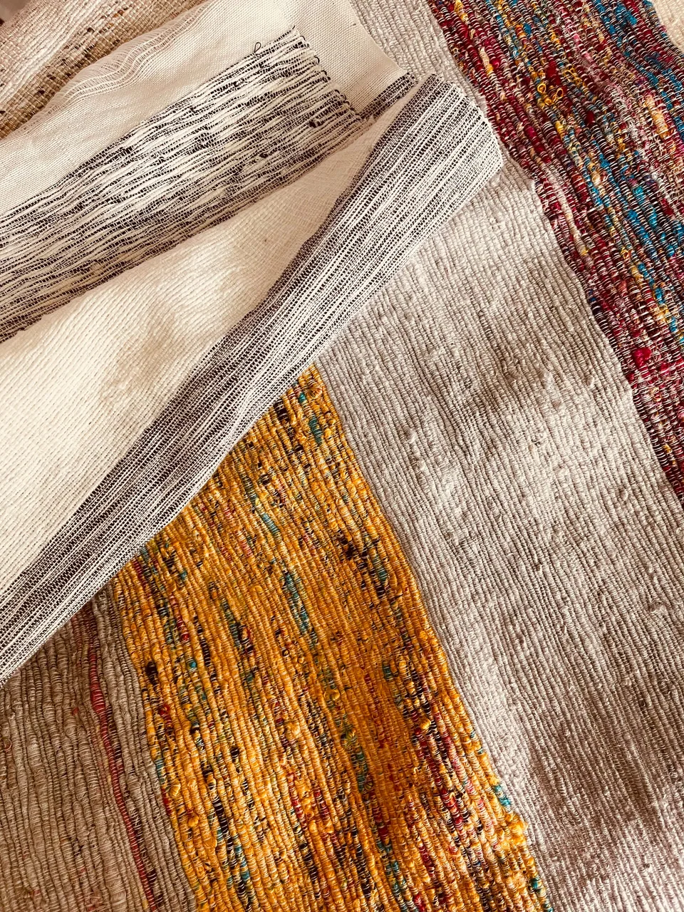 Folded handwoven fabrics stacked with their edges showing