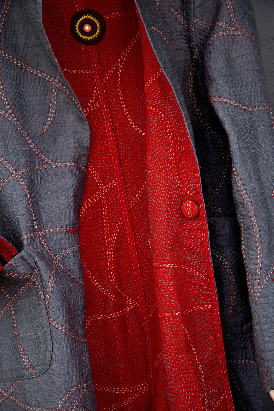 The coat worn grey side out with the red showing at the opening