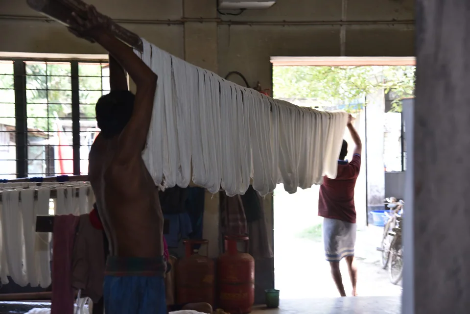 Hanging washed yarn to dry across a bright doorway