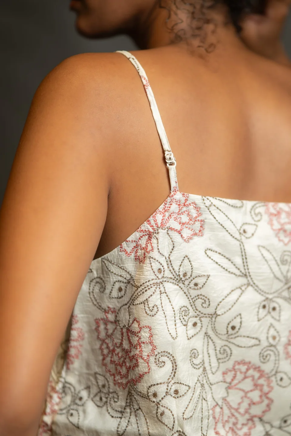 Back view of a hand-embroidered cami, running-stitch flowers on unbleached cotton