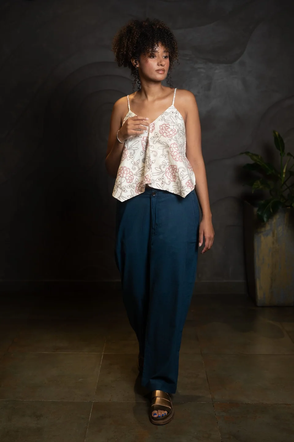 Silk kantha cami and teal trousers, hands held together at the waist