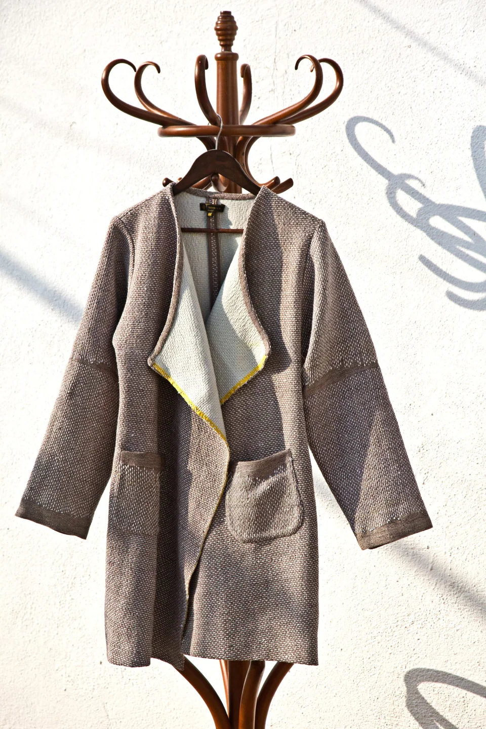Grey kantha shawl coat on a wooden stand