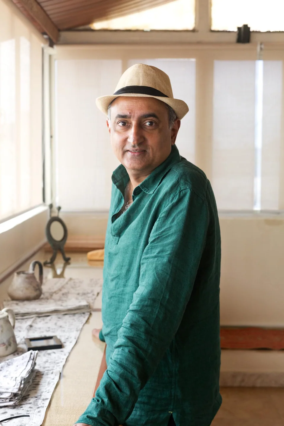 Mahesh Balasubramaniam in the workroom, block-printed cloth laid out behind him