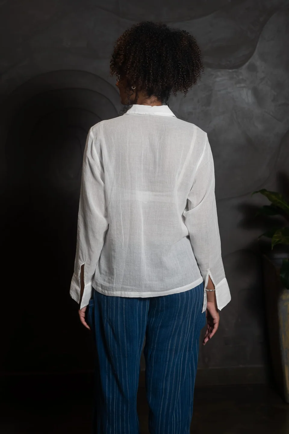 Back view of the sheer white muslin shirt, light coming through the cloth