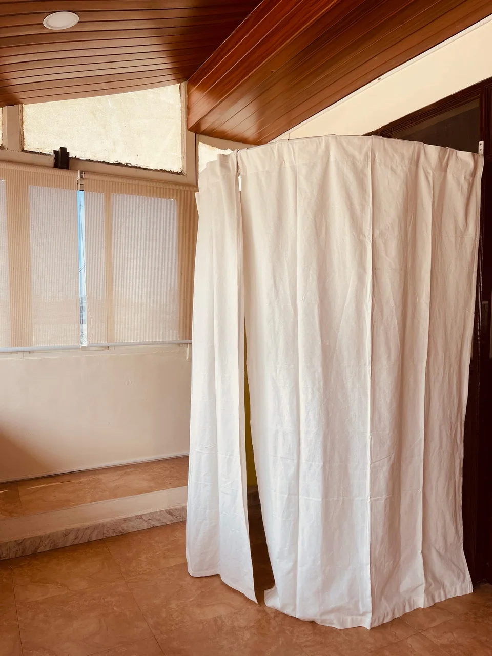 A quiet corner of the studio with a curtained changing space