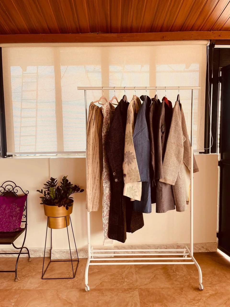 A corner of the Bengaluru studio, garments on a rail beside a shuttered window