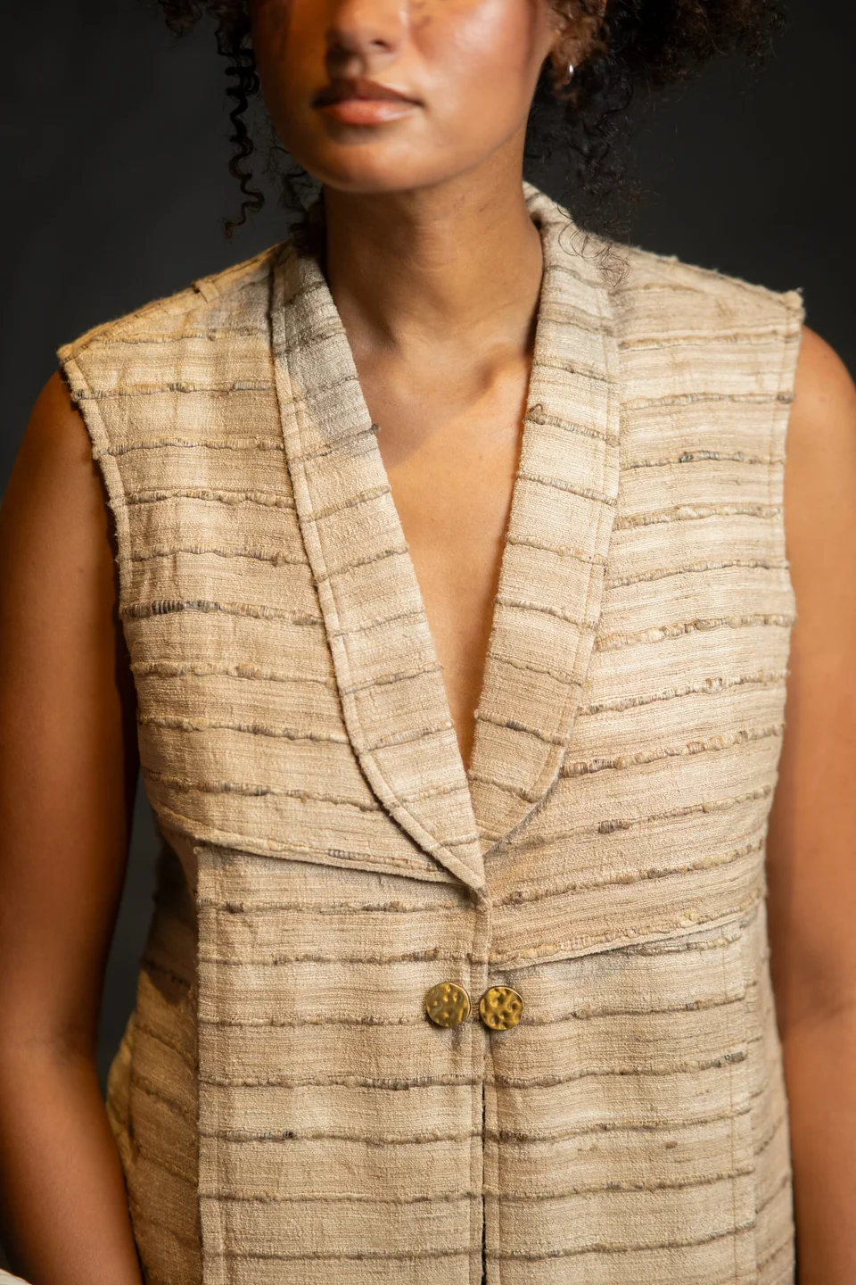 Tussar silk waistcoat with two hammered brass buttons, seen close