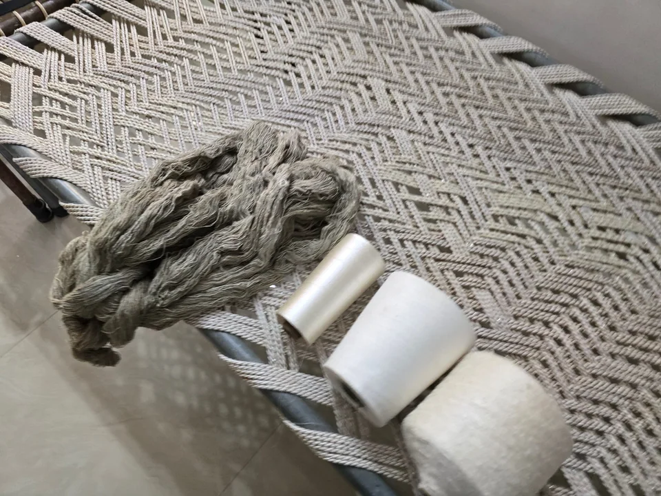 Hand-spun yarn and cones resting on a woven cot